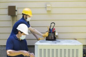 two-technicians-working-on-outside-air-conditioner